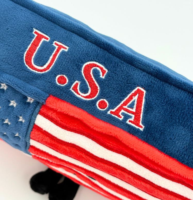 Stuffed American Flag plush featuring 50 stars and 13 stripes, measuring 10 inches by 6 inches by 2 inches, perfect for collectors and gifts.